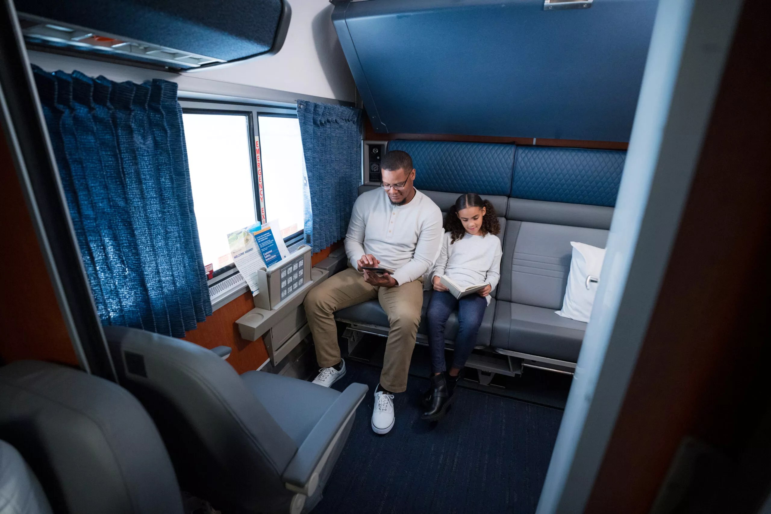 Man and child sit on a amtrak train