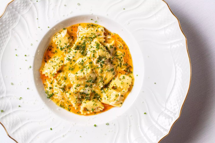 a yellow pasta on a white plate