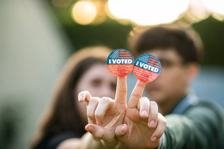 A couple holding up I Voted stickers.