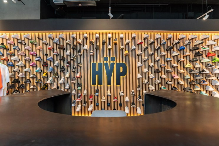 Wall display of colorful sneakers and the Hÿp logo inside the flagship store at Miami Worldcenter