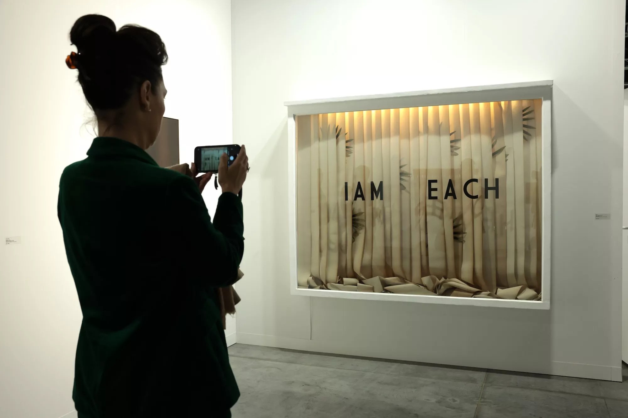Woman snapping a photo of an artwork at Art Basel Miami Beach 2024