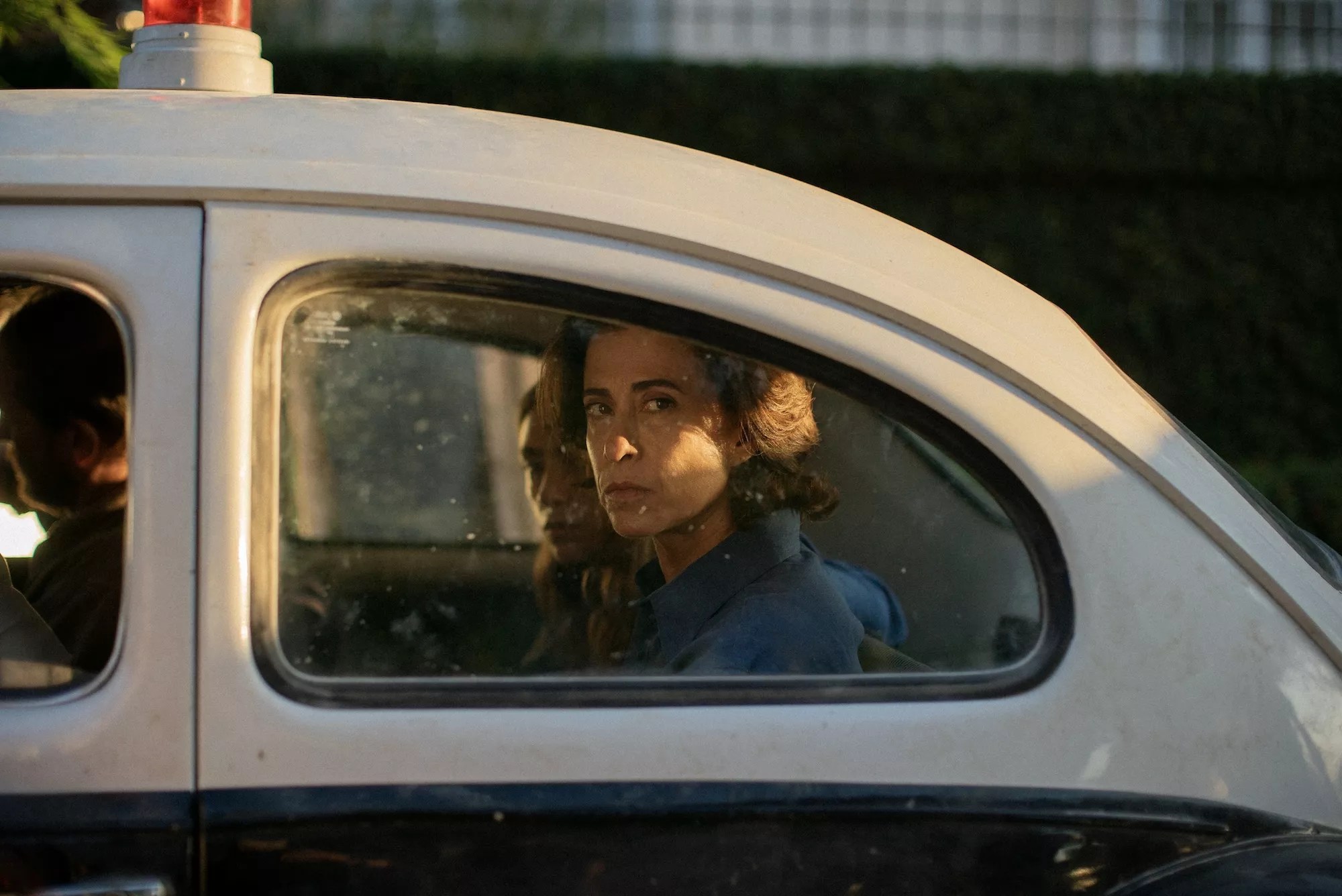 film still from <i>I'm Still Here</i> with Eunice looking through the back window of a vintage car
