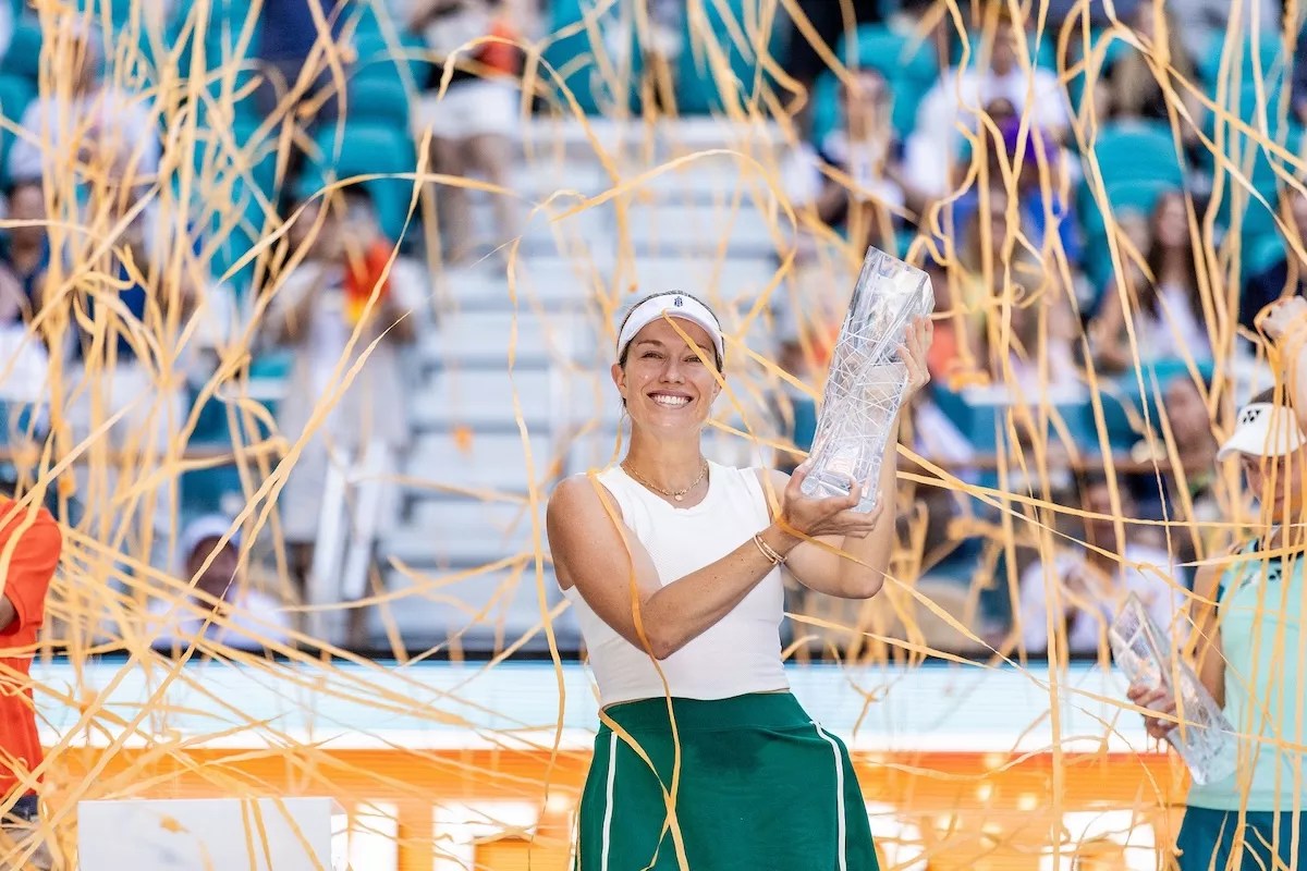 Tennis player Danielle Collins holds a trophy as streamers fly around her