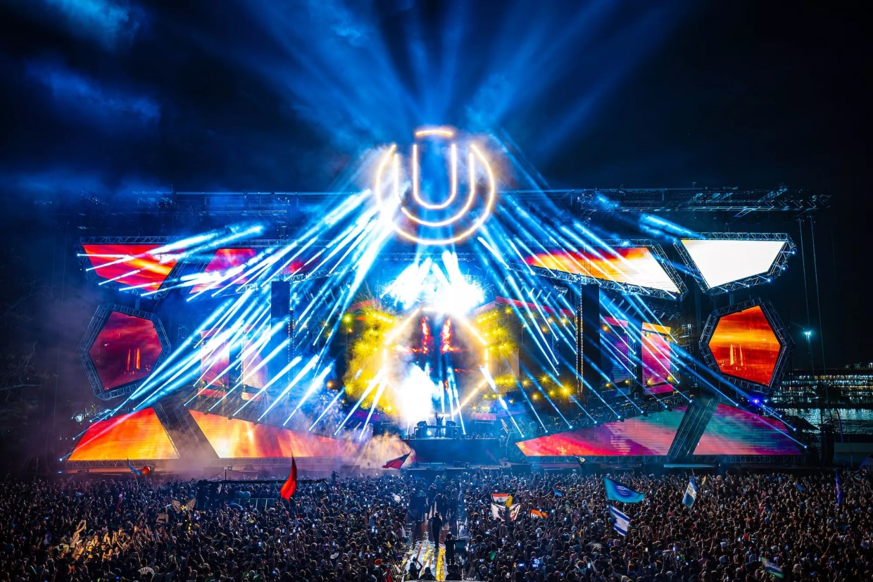 Photo of a stage with colorful LED lights and a u shaped logo.