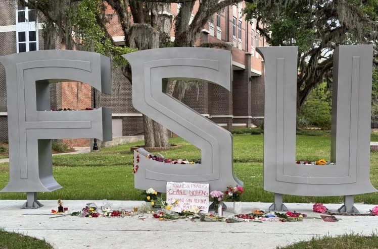 An FSU sign with a message affixed to it which reads, "Thoughts and prayers change nothing. We want gun reform!"
