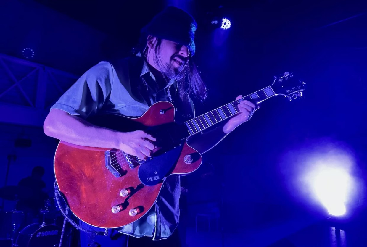 A guitarist playing a red Gretsch