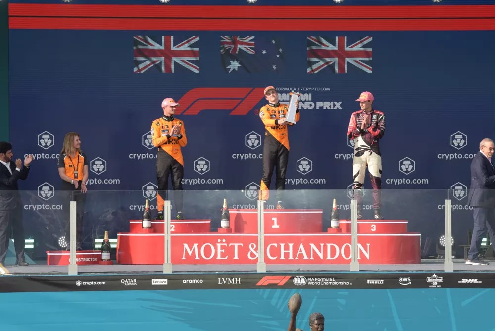 Three F1 race car drivers on the podium