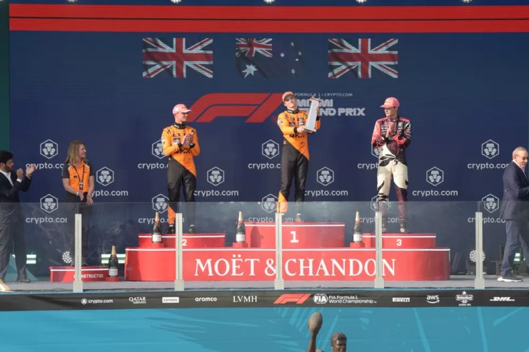 Three F1 race car drivers on the podium