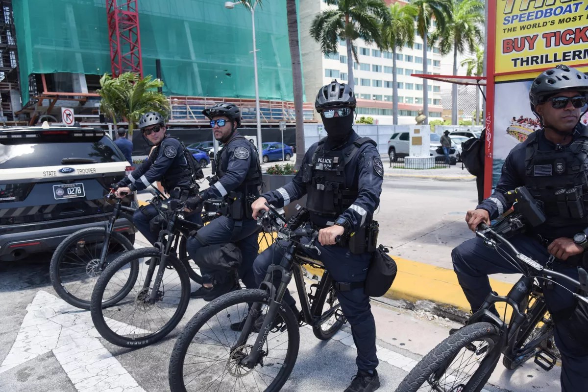 Miami Police Department bicycle officers stand ready at an anti-Trump protest.