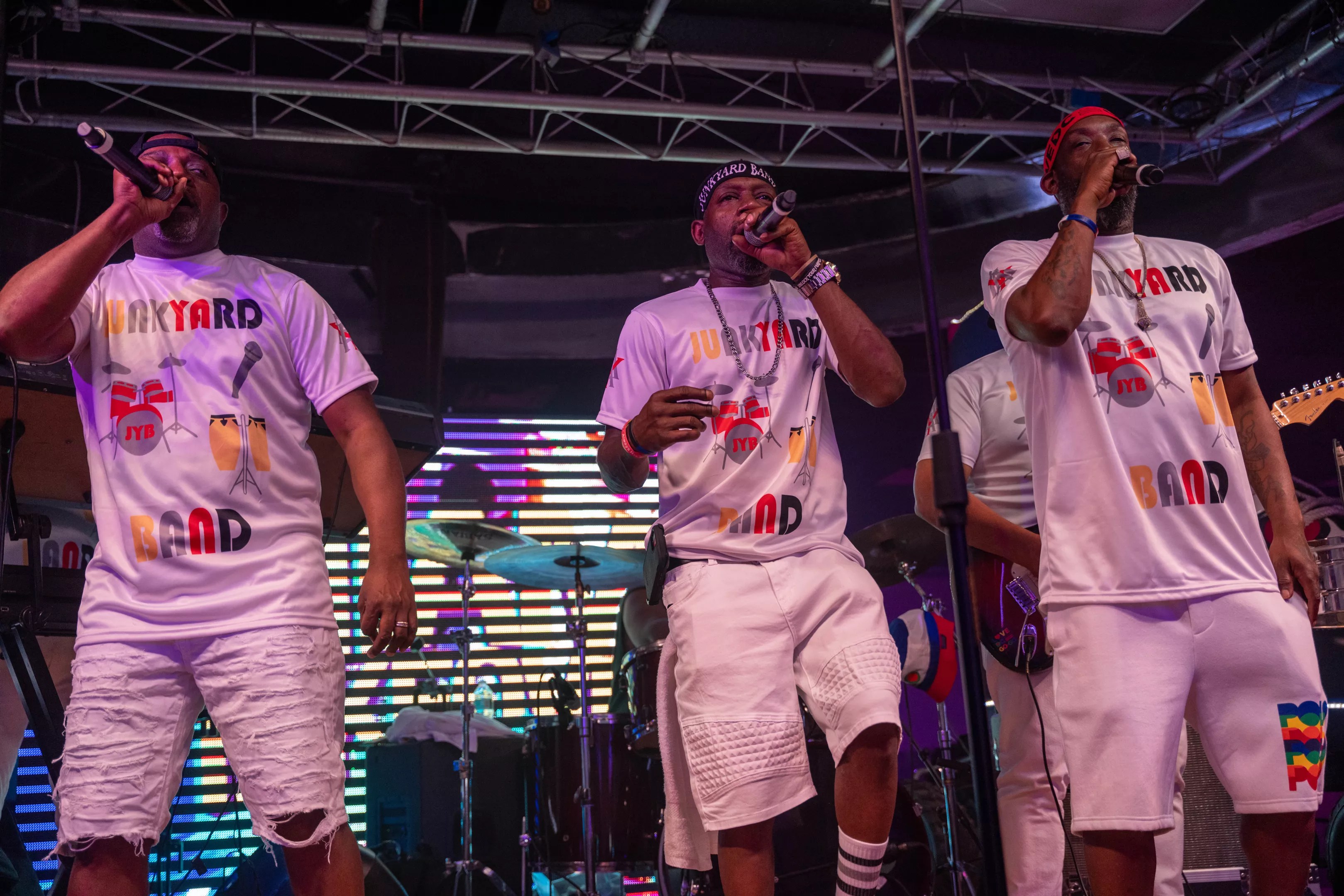 A three-piece band singing on stage