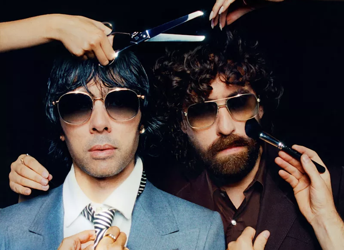 Two men are putting on makeup and getting a haircut