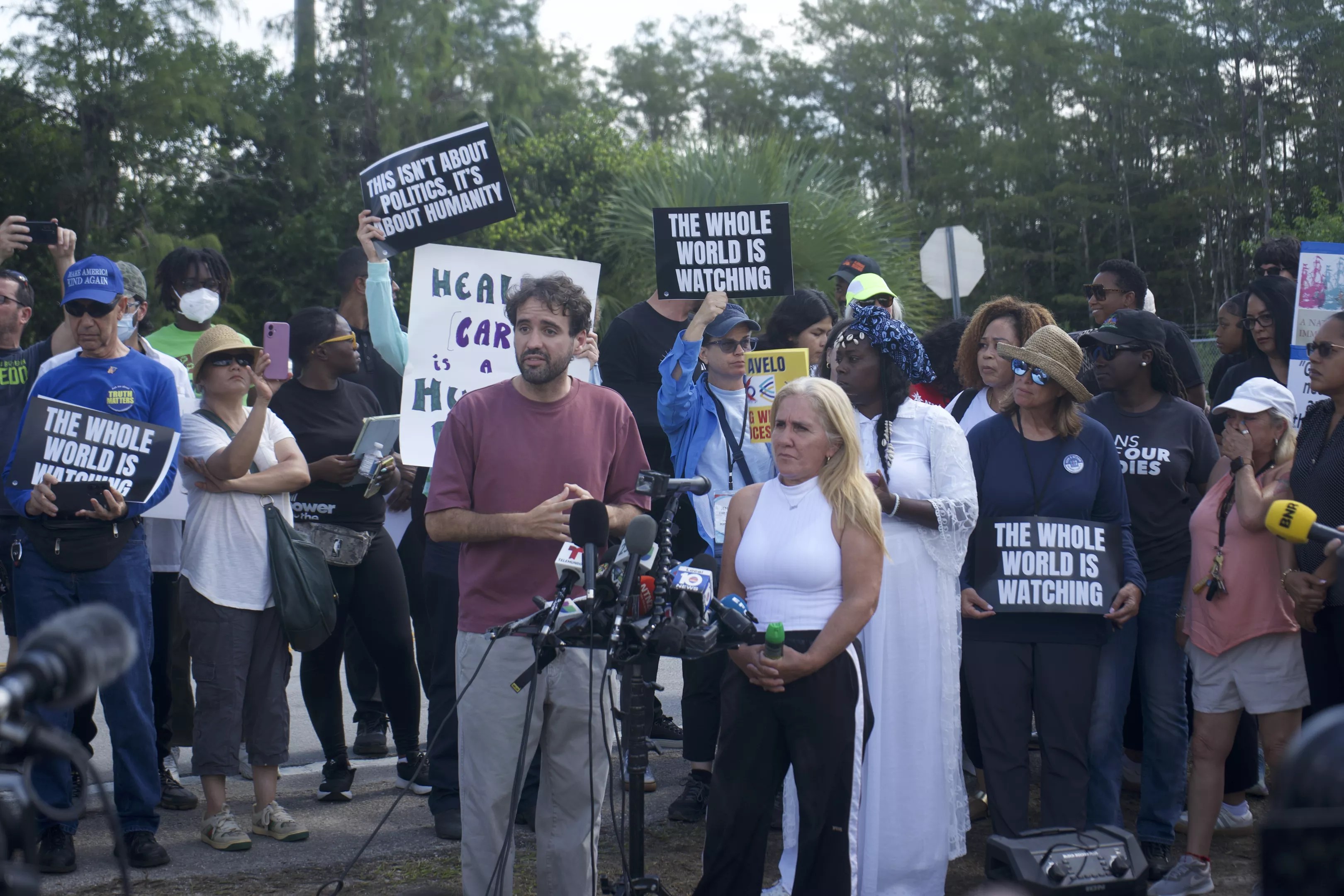 A woman speaks to reporters about her husband's experience in Alligator Alcatraz.