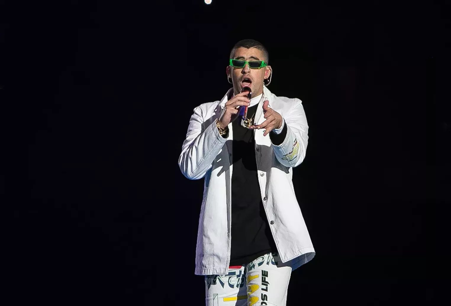 A man dressed in white holding a microphone