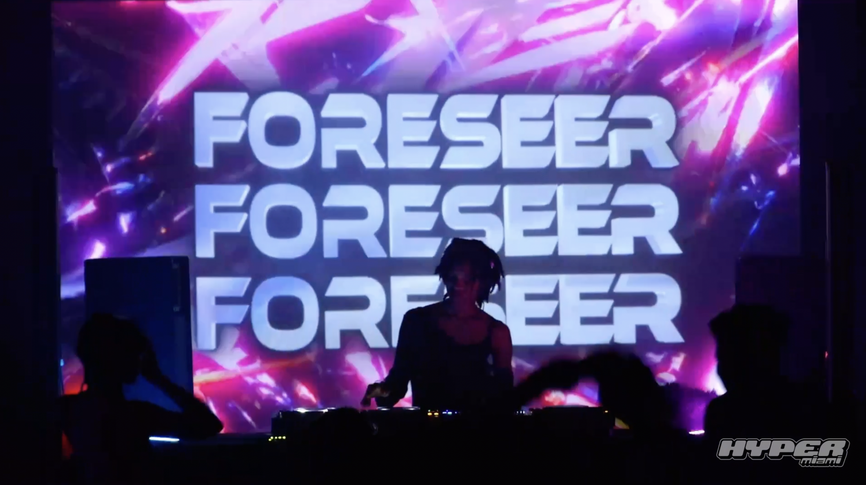 DJ is playing in front of an LED screen.