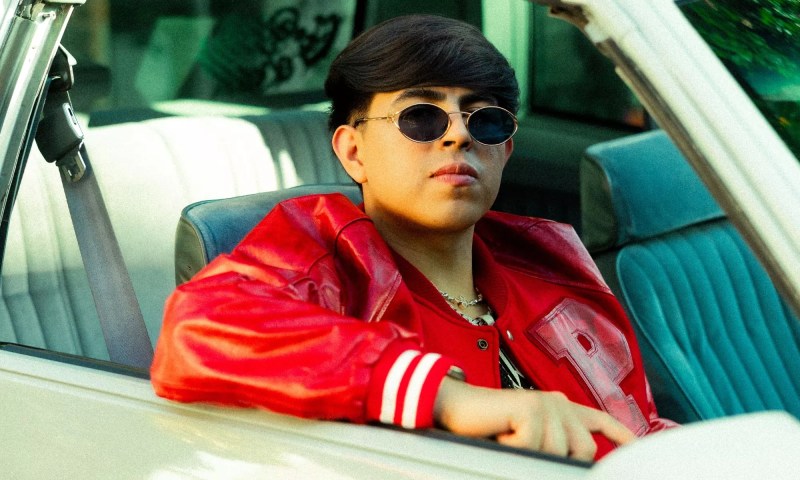 Picture of a young Latin man inside a convertible car wearing sunglasses
