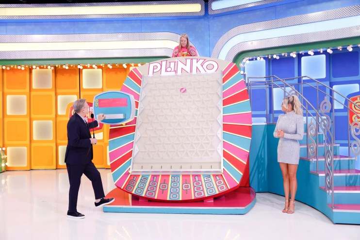 A game show host and model stand on either side of a gameboard reading "Plinko." A woman stands above the gameboard
