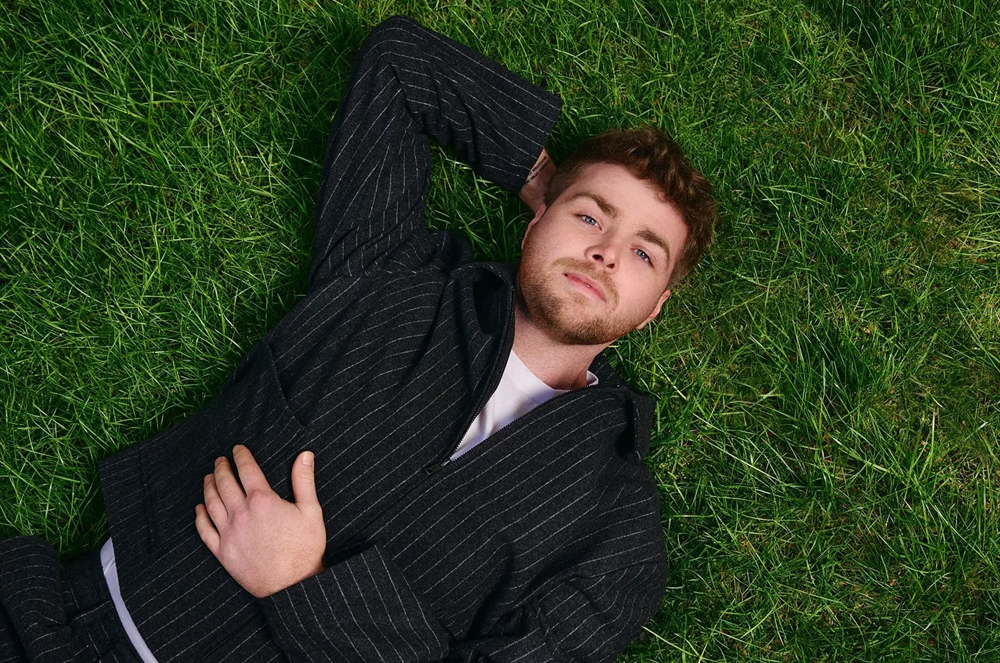 Picture of a young man lying on the grass.