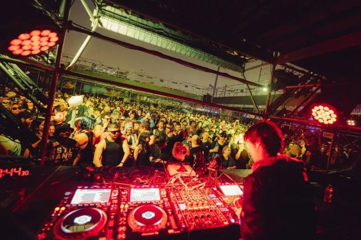 Picture of a DJ in front of a crowd.