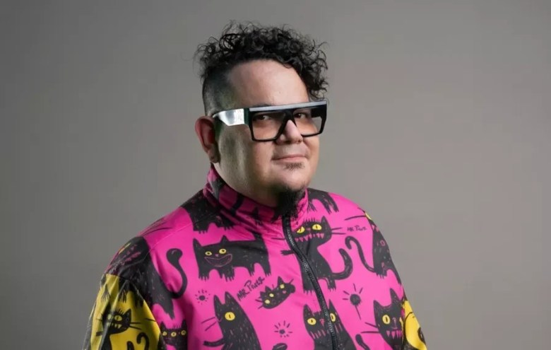 Portrait of a man wearing glasses and a colorful jacket.