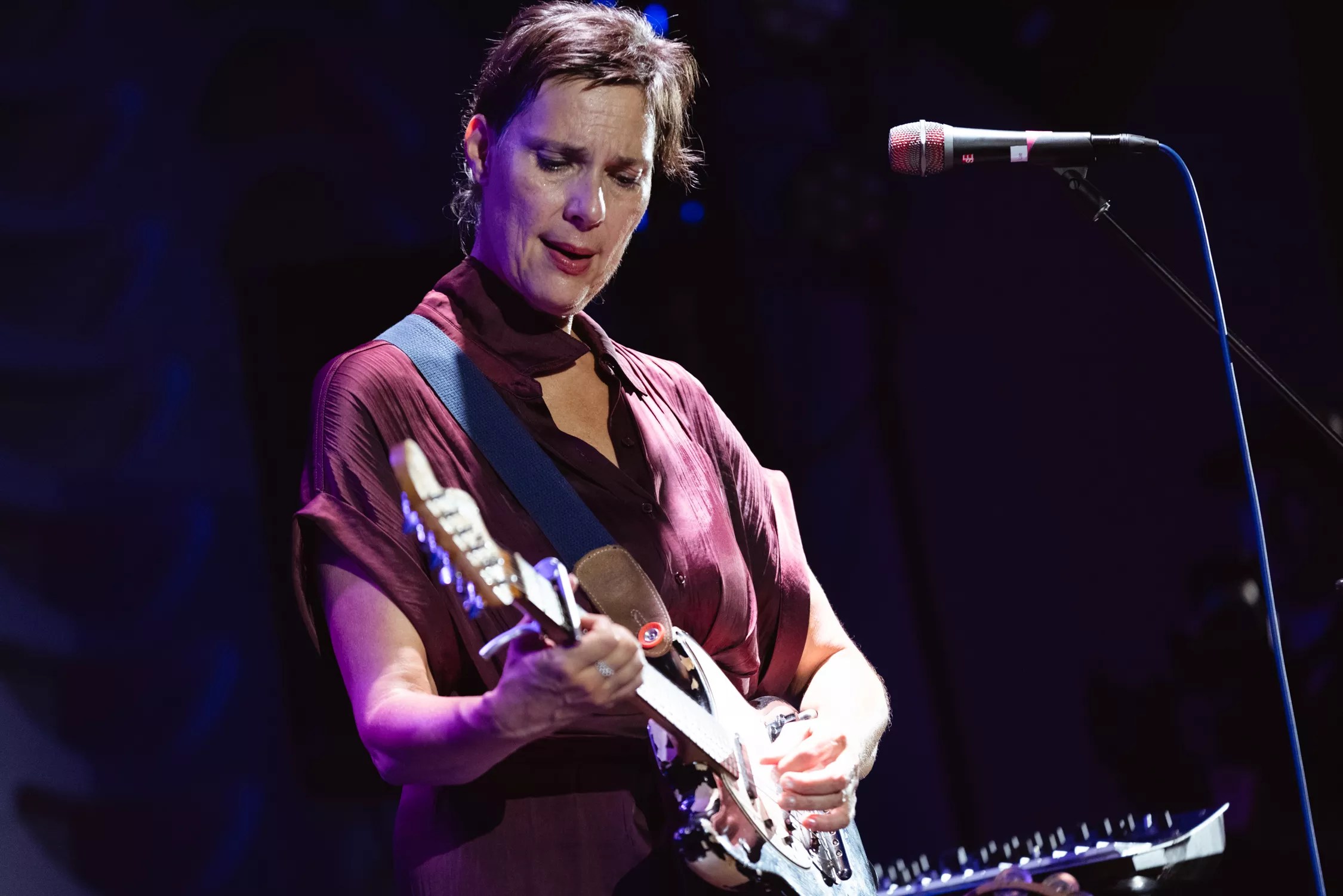 A woman playing an electric guitar.
